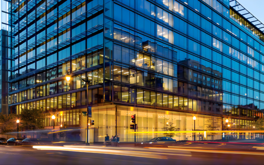 Corner view of 800 17th Street NW at dusk with reflections of city lights and nearby buildings in downtown Washington DC.